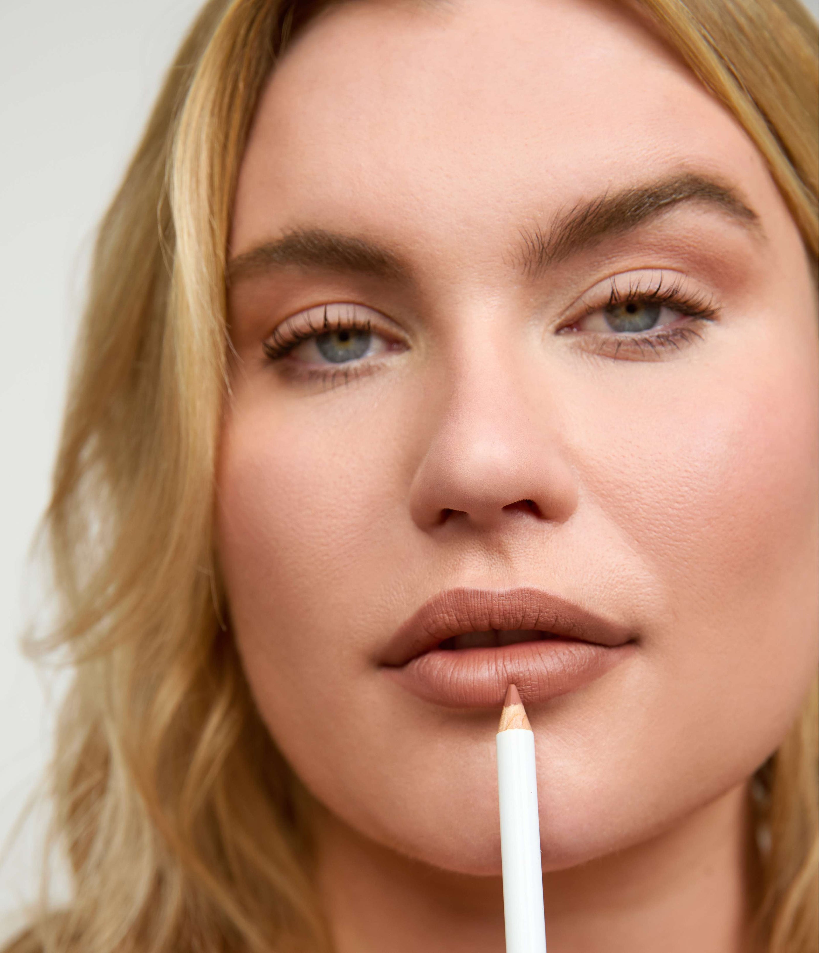 Close-up of model applying Eye/Lip Multi Use Pencil Nude