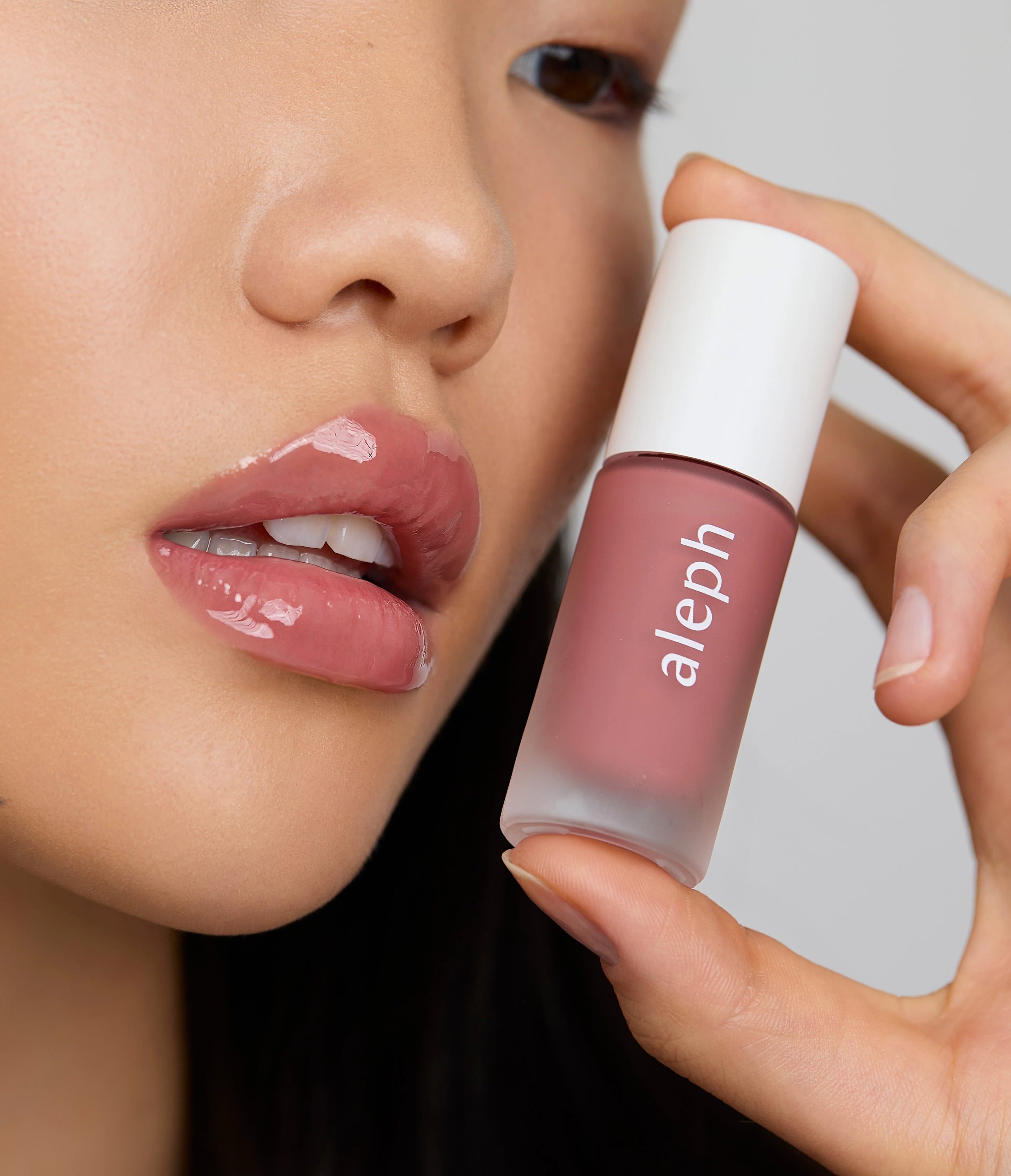 Model wears Aleph Beauty Aura Gloss in Bare